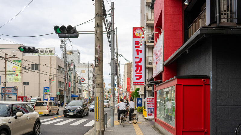 道沿いにカラオケ店「ジャンカラ」が見えますので、向かいの信号を渡ってください。